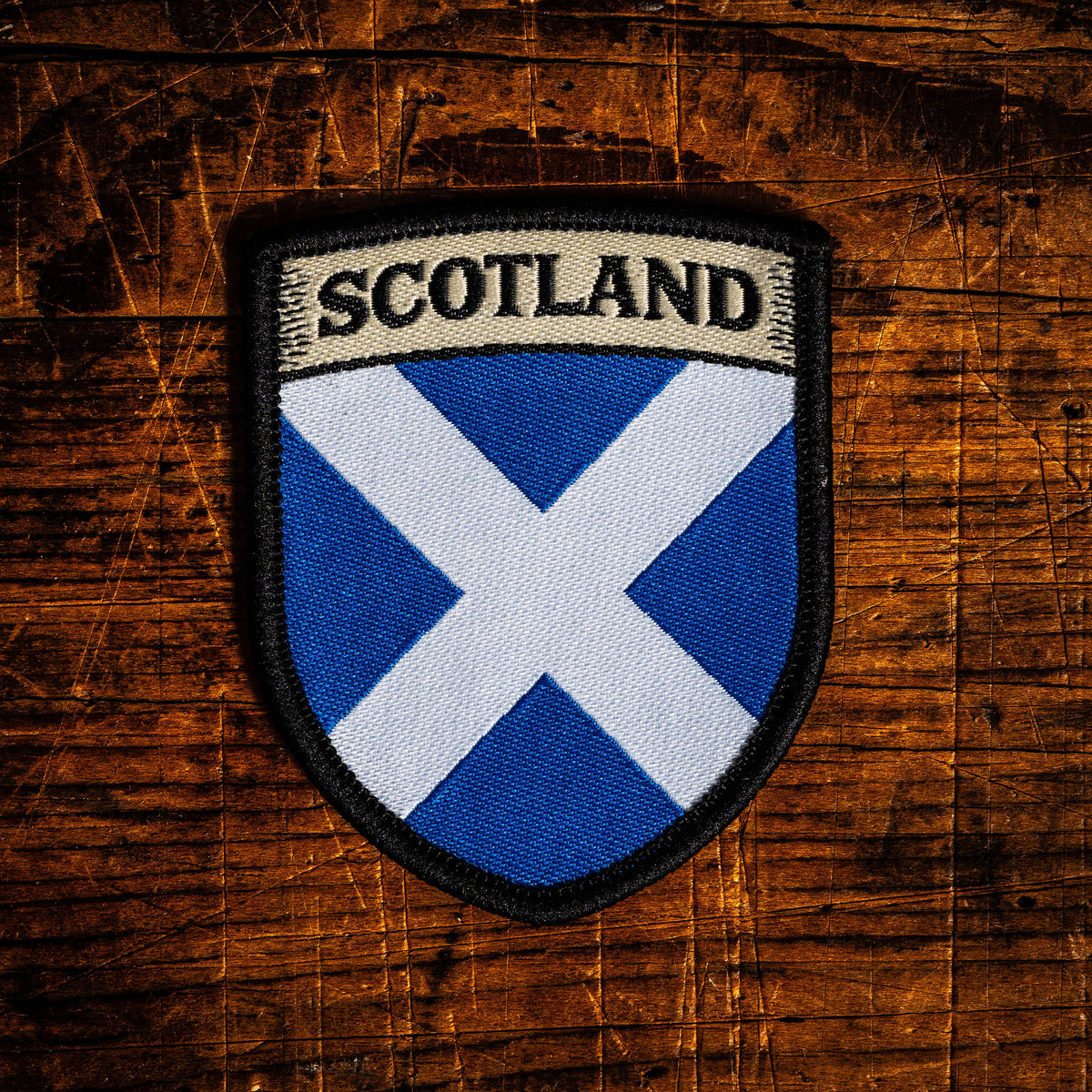 Scottish flag patch on a wooden background