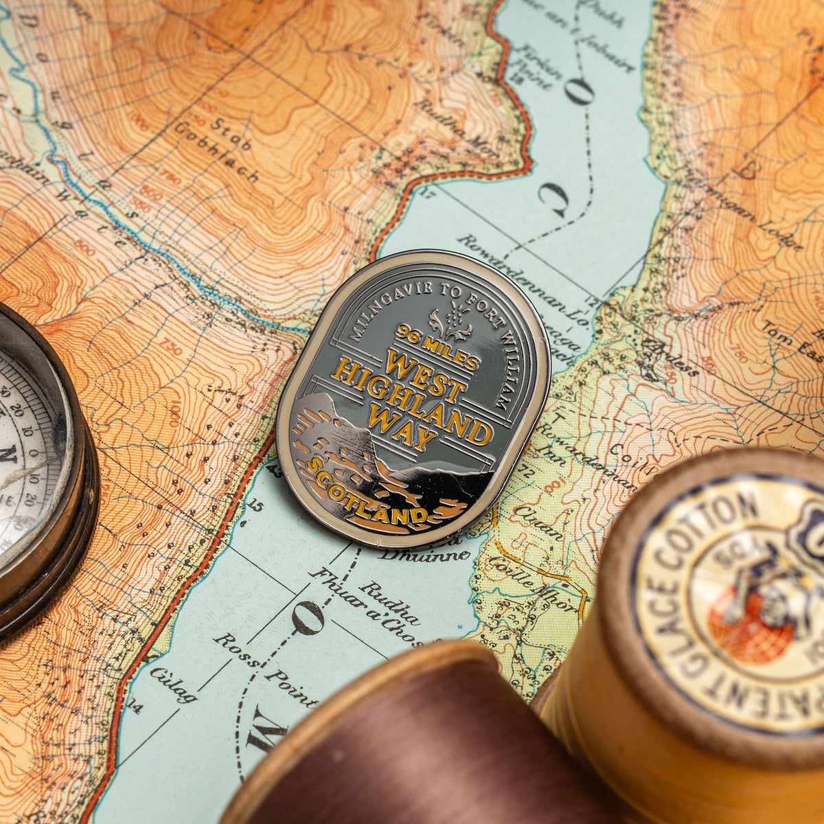 West Highland Way pin lifestyle shot on outdoor gear - hard enamel adventure pin