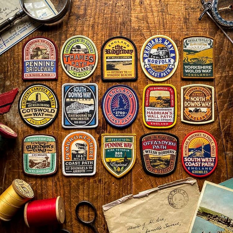 All 15 National Trail patches laid out – Pennine Way patch included in retro woven collection