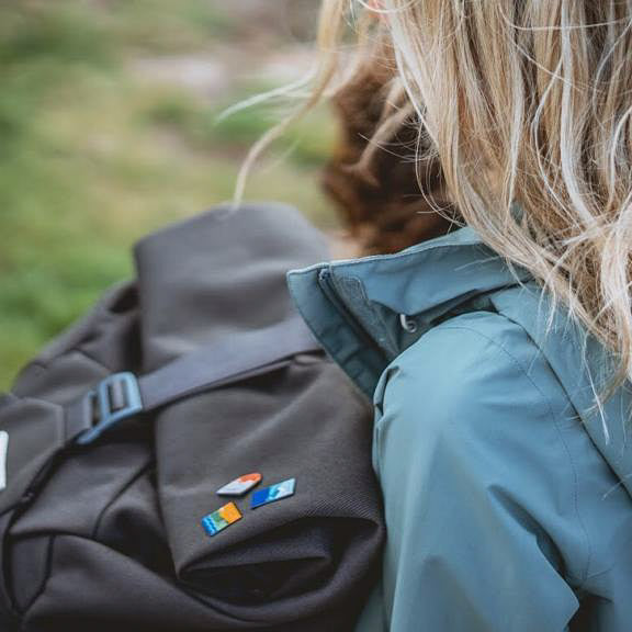 UK National Park enamel pins on a rucksack – Northumberland pin included in outdoor collection