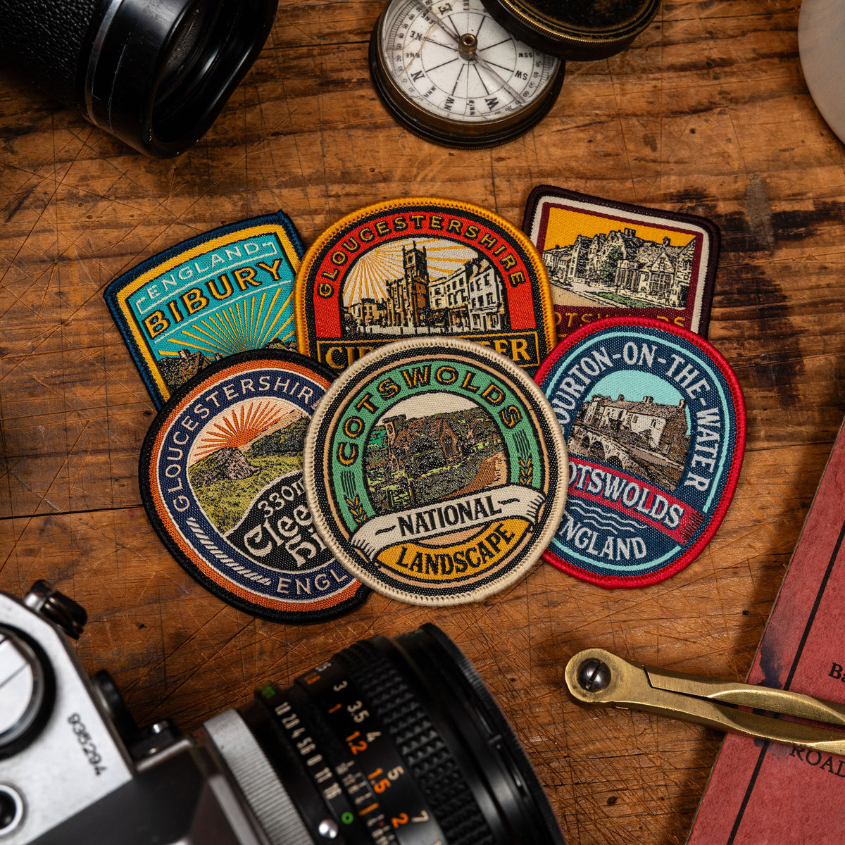 Cotswolds patches collection flat-lay - retro woven hiking patches celebrating Cotswolds hills and landmarks