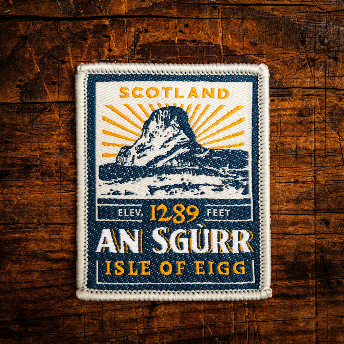 An Sgurr (Eigg) retro woven patch - iconic basalt pinnacle on Isle of Eigg, Scotland, whisky label design