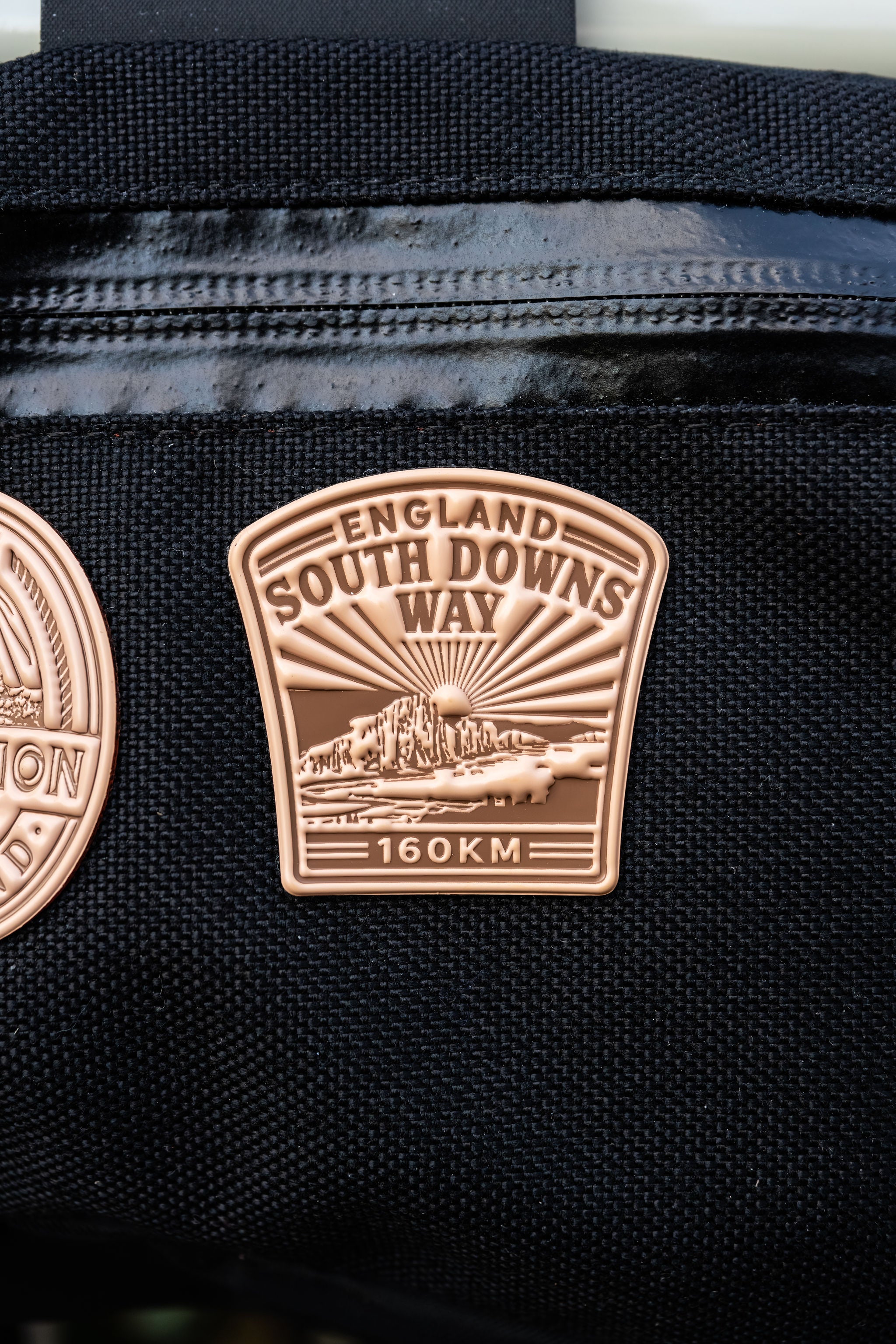 Bikepacking patches flat-lay including South Downs Way - retro woven cycling route patches