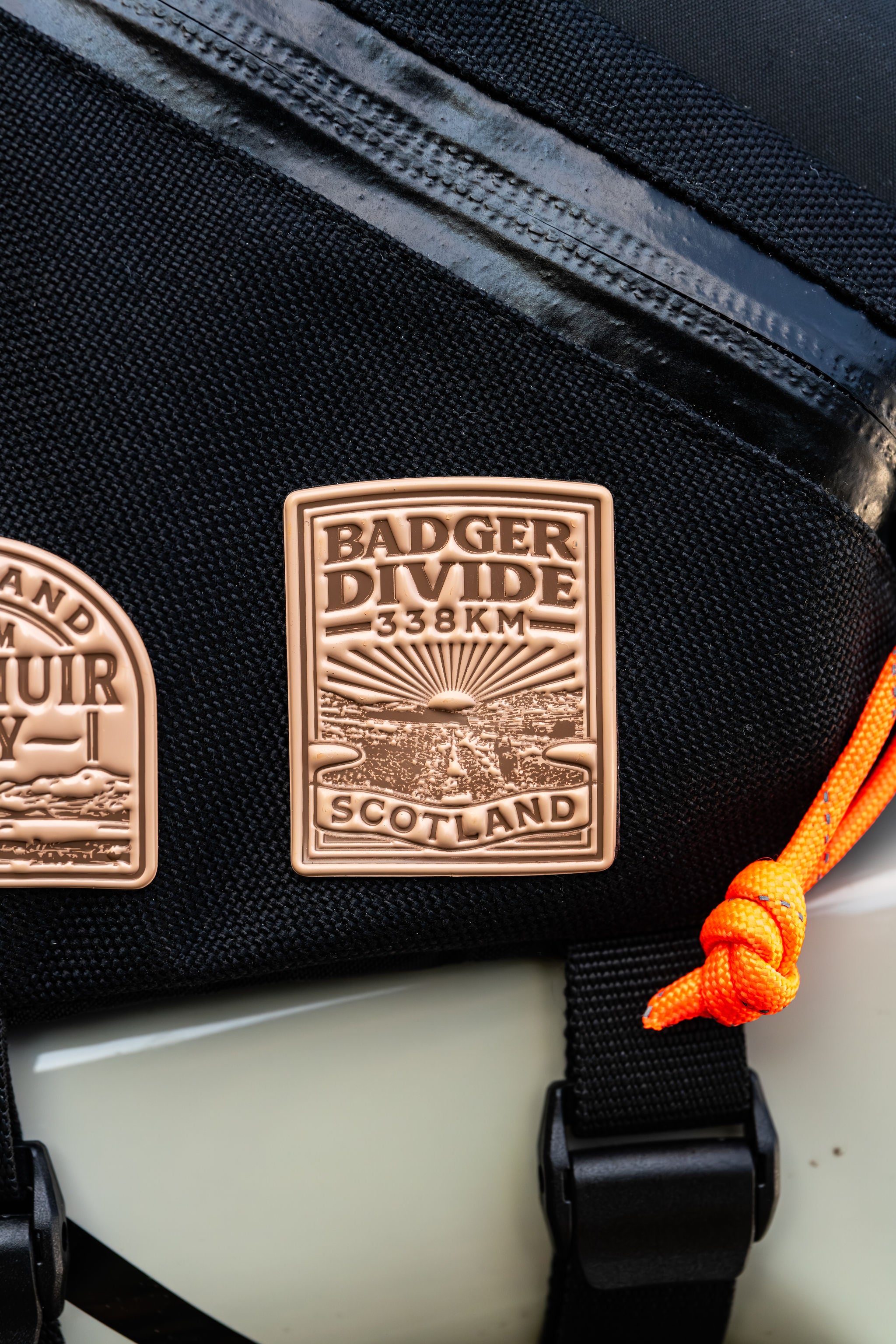 Bikepacking patches flat-lay including Badger Divide - retro woven cycling route patches
