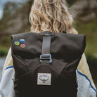 Osprey rucksack with UK National Park enamel pins – female outdoors with pin collection on pack