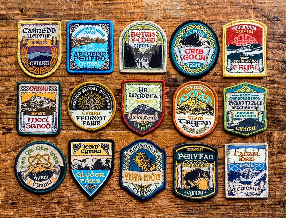 Welsh Mountain patches full set of 15 laid out on a surface – Celtic design retro woven hiking patches
